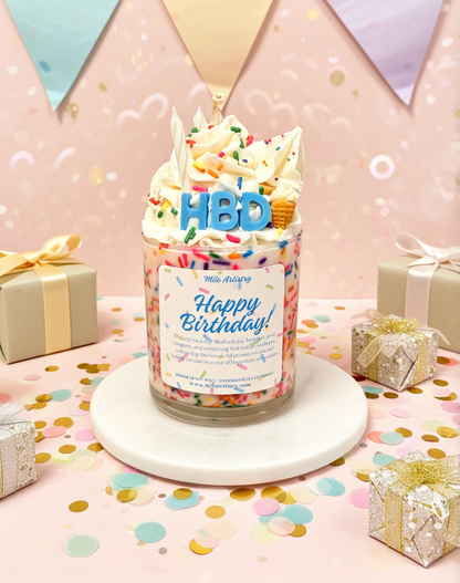 Birthday-themed candle with 'HBD' on top, surrounded by gift boxes and confetti on a pink background.